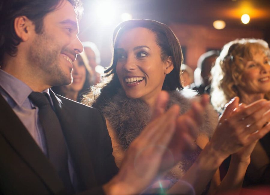 Close up of couple clapping in theater