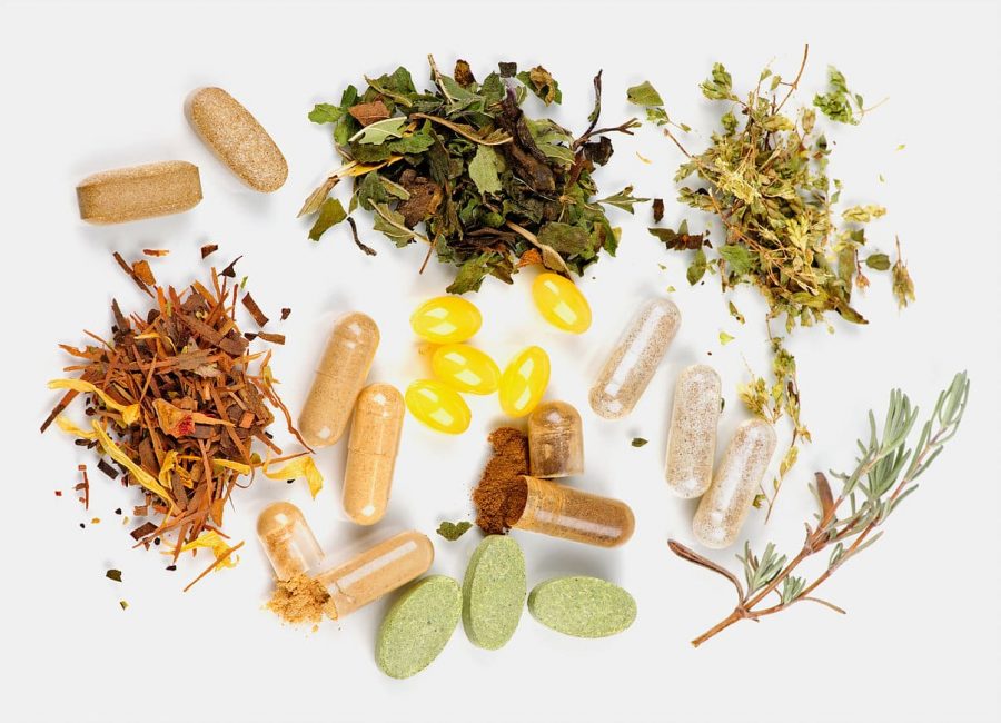 Herbs,  herbal supplements and vitamin pills on white background