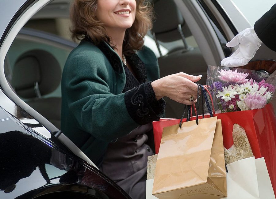 Woman handing shopping bags to valet